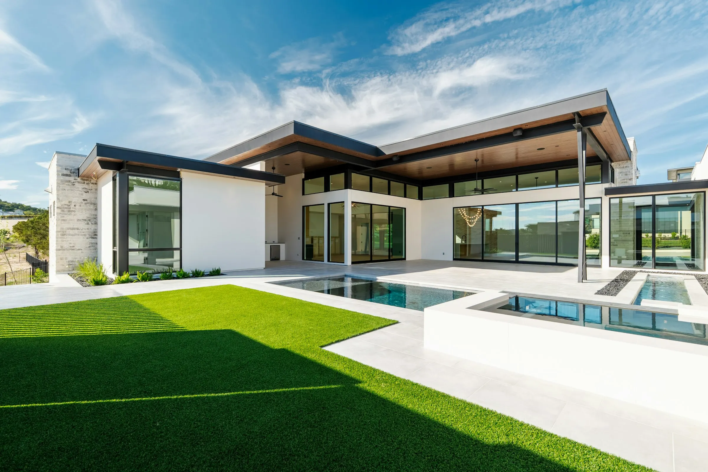 Contemporary white home with a pool and a clean-edged lawn